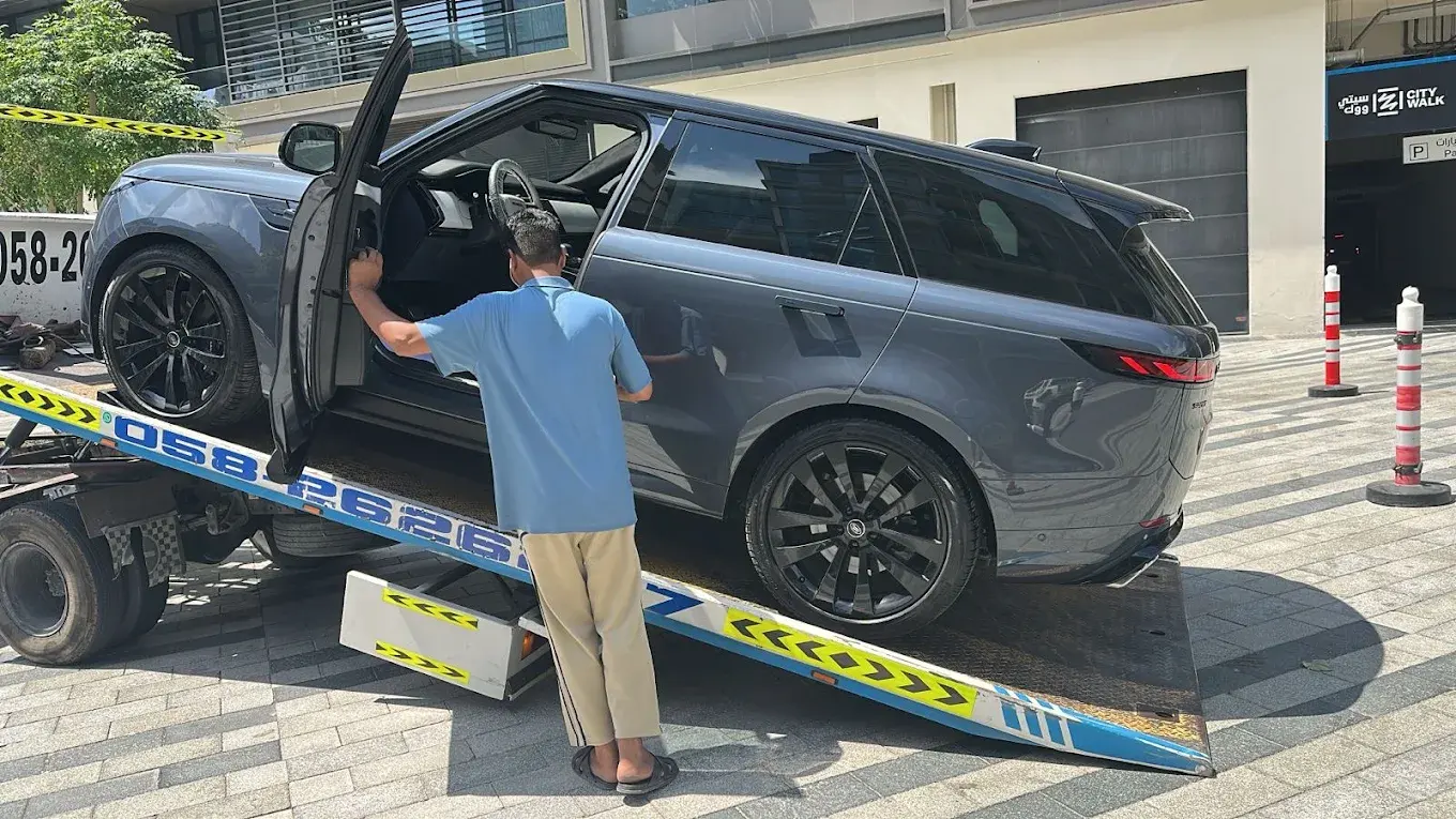 Range Rover loaded onto a recovery truck for free pickup and drop-off in Dubai