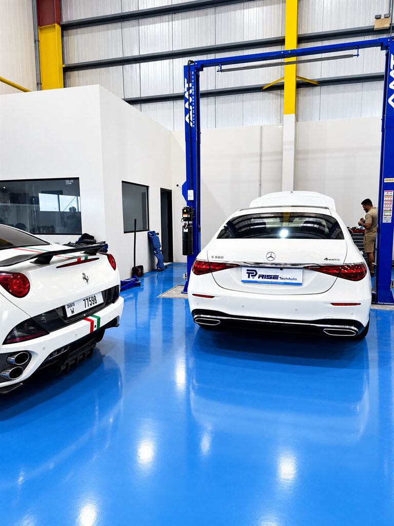Clean luxury car workshop with a blue floor at Rise Tech Auto in Dubai Investment Park